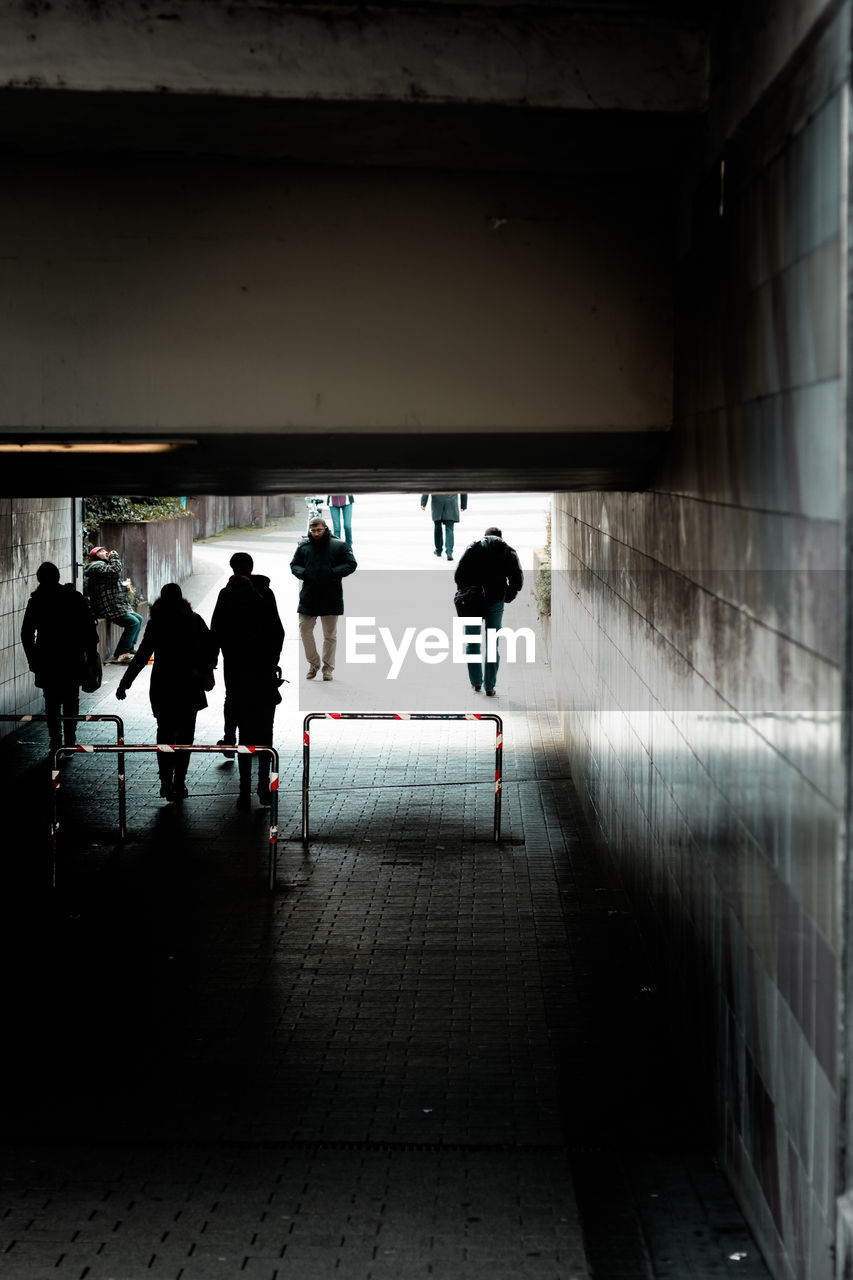 Silhouette people at an underpass