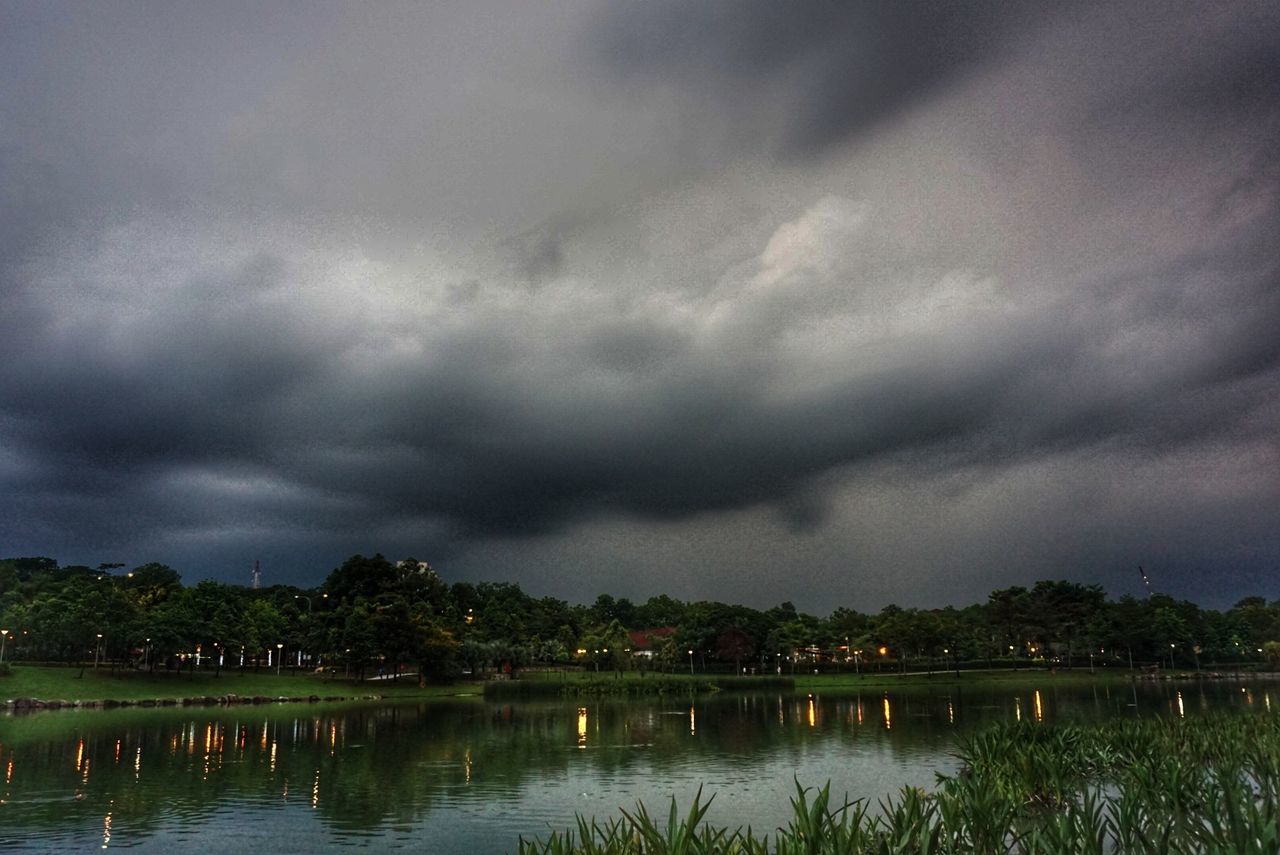 SCENIC VIEW OF LAKE AGAINST STORM CLOUDS OVER LANDSCAPE
