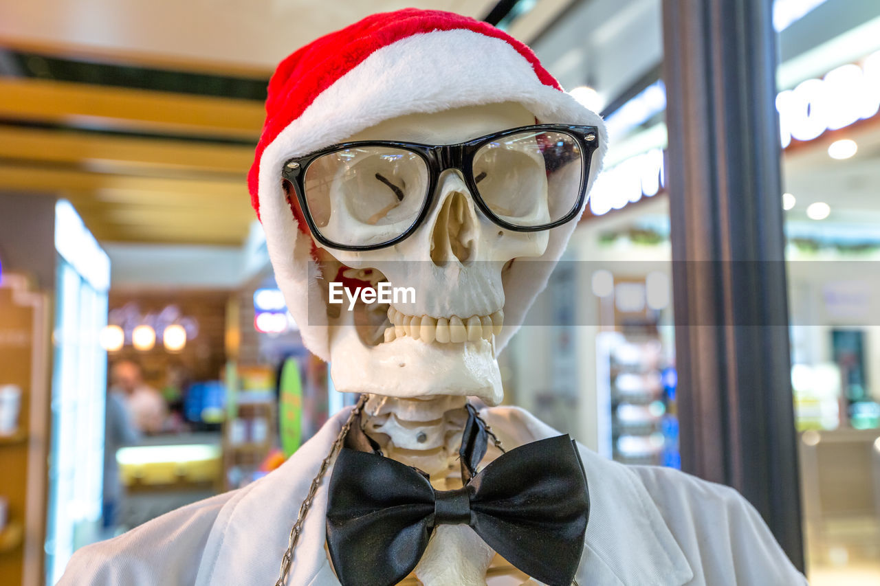 Close-up of person wearing mask and santa hat