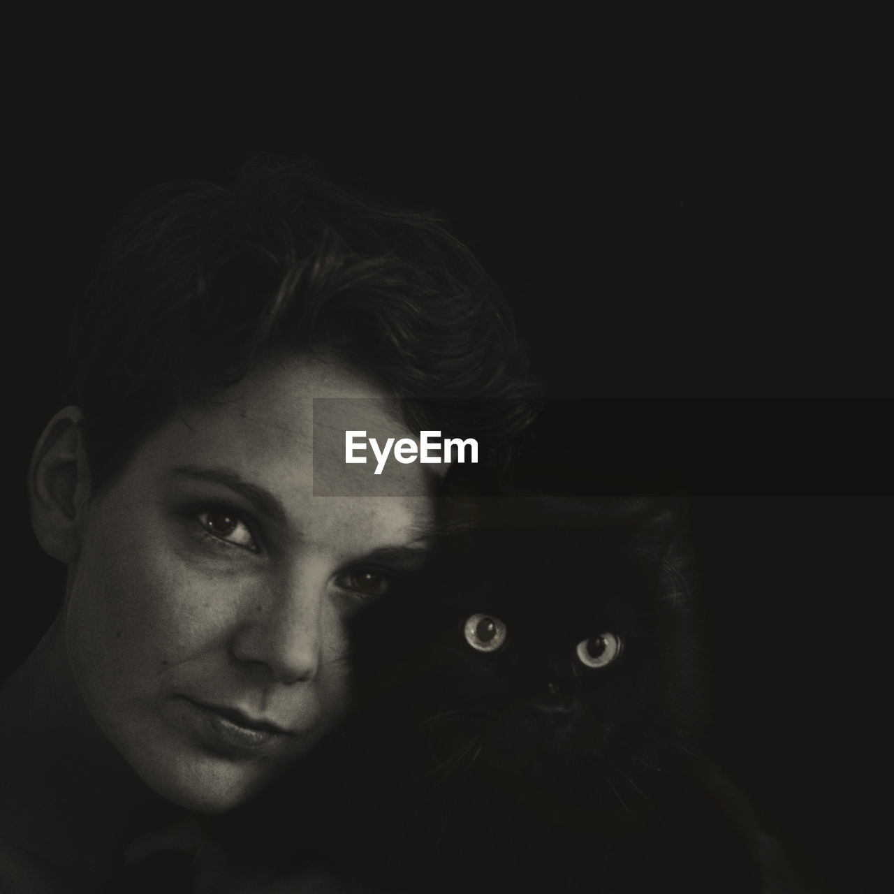 Portrait of woman with cat in darkroom