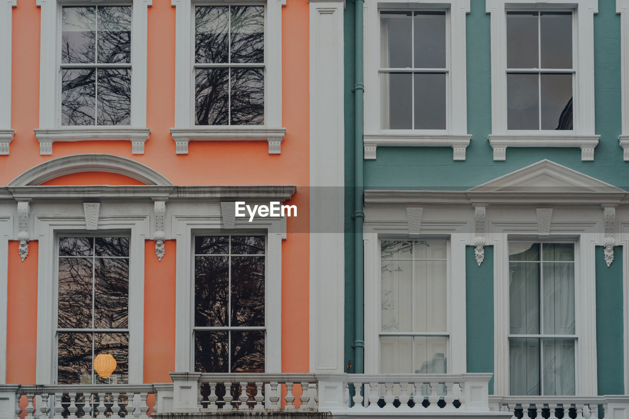 Close up of orange and turquoise pastel coloured terraced houses in primrose hill, north london, uk.