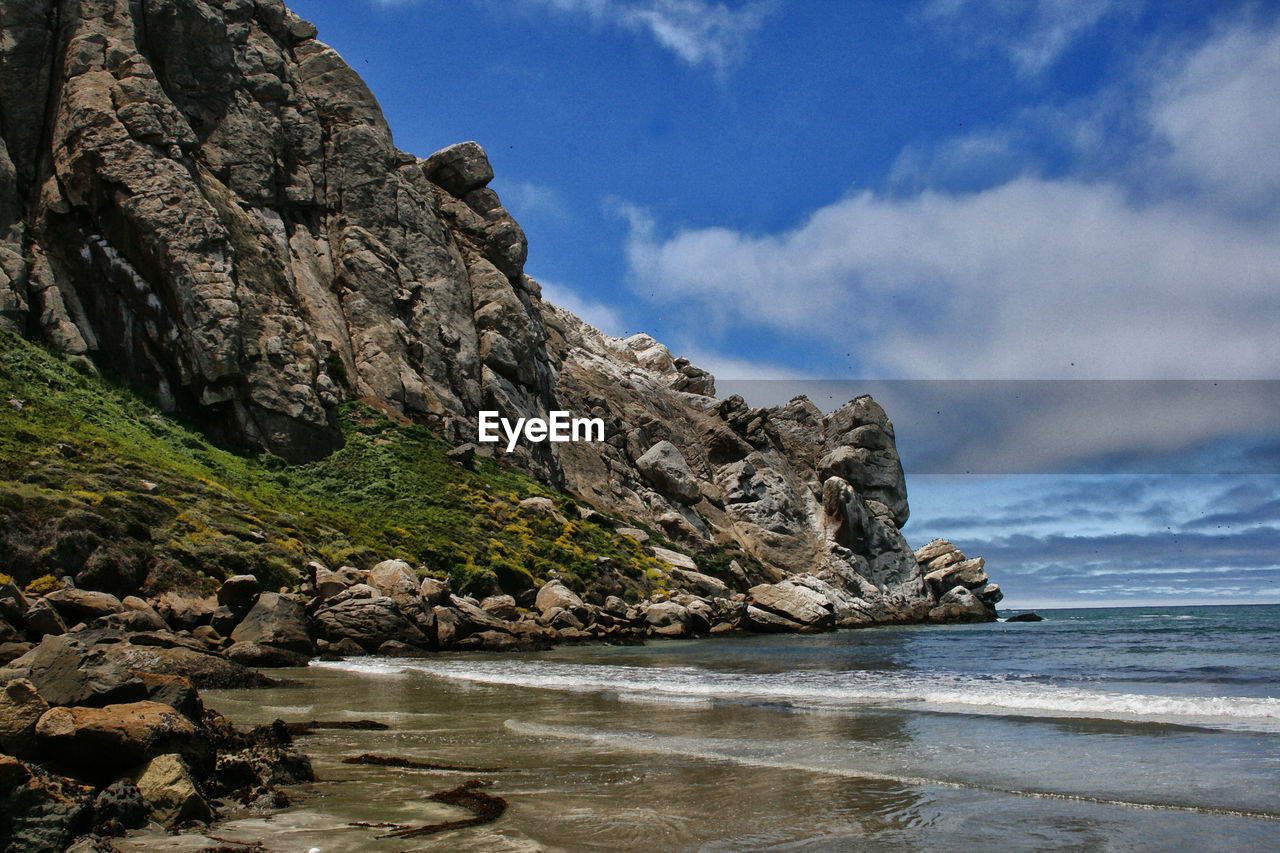 Rock formations by sea against sky