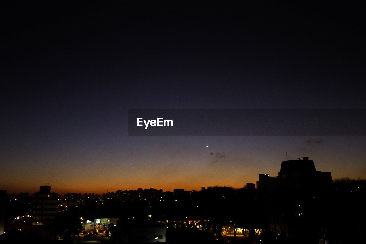 VIEW OF ILLUMINATED CITYSCAPE AT NIGHT