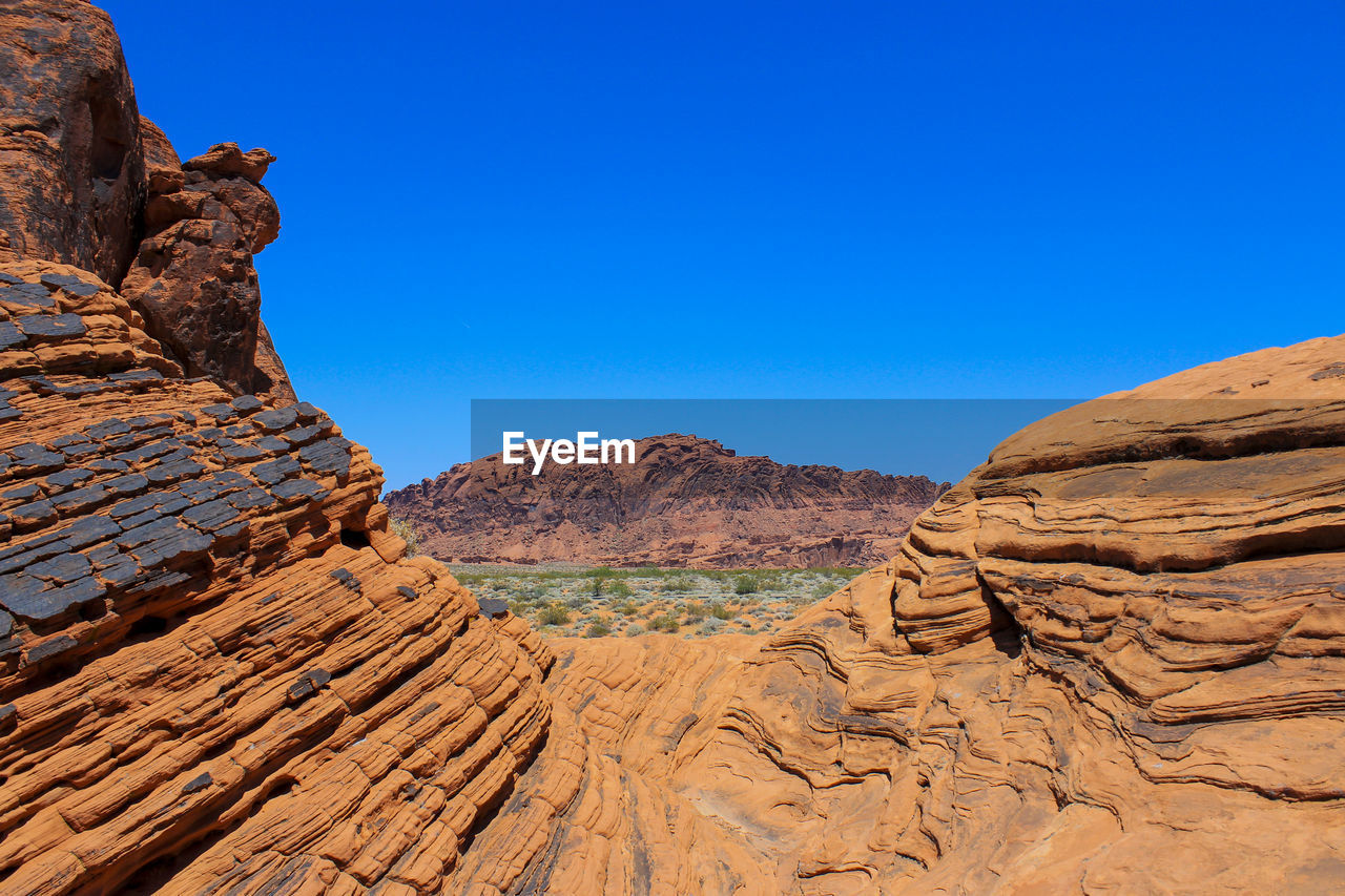 Rock formations in desert against blue sky