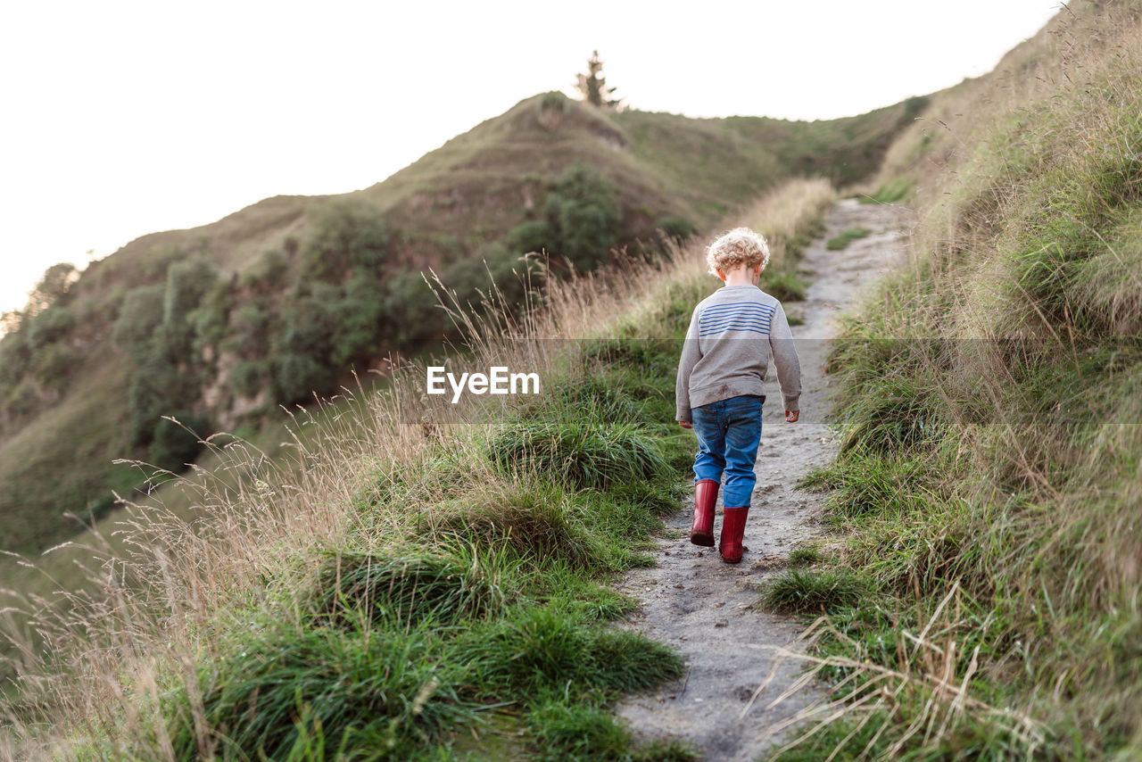 Preschool aged child walking on hillside path