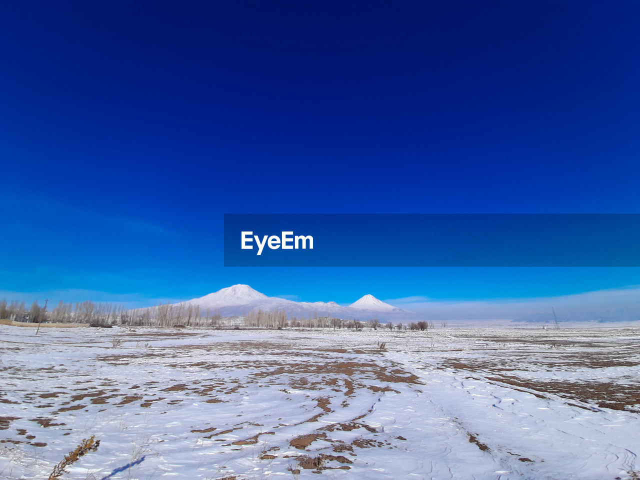 Scenic view of snowcapped mountains against blue sky