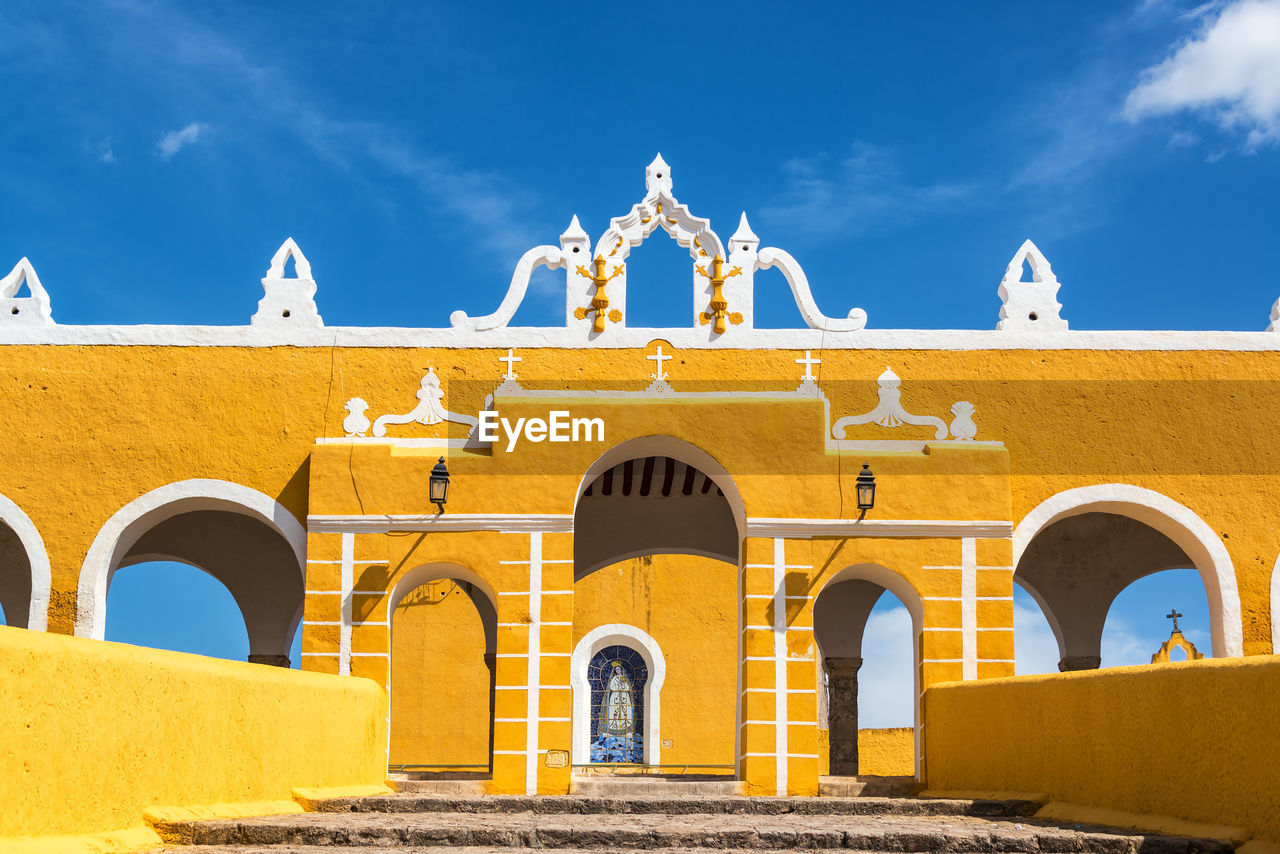 Low angle view of yellow monastery against sky