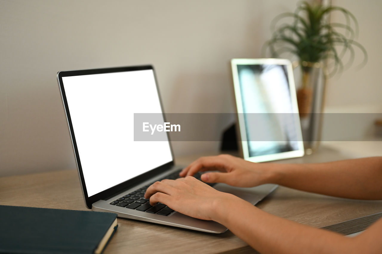 midsection of woman using laptop on table