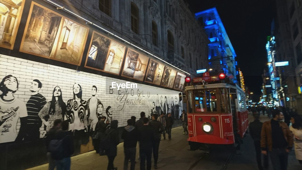 PEOPLE IN ILLUMINATED CITY AT NIGHT