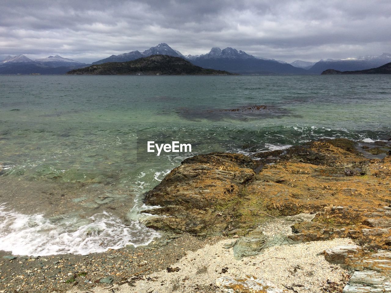 SCENIC VIEW OF SEA AGAINST MOUNTAINS