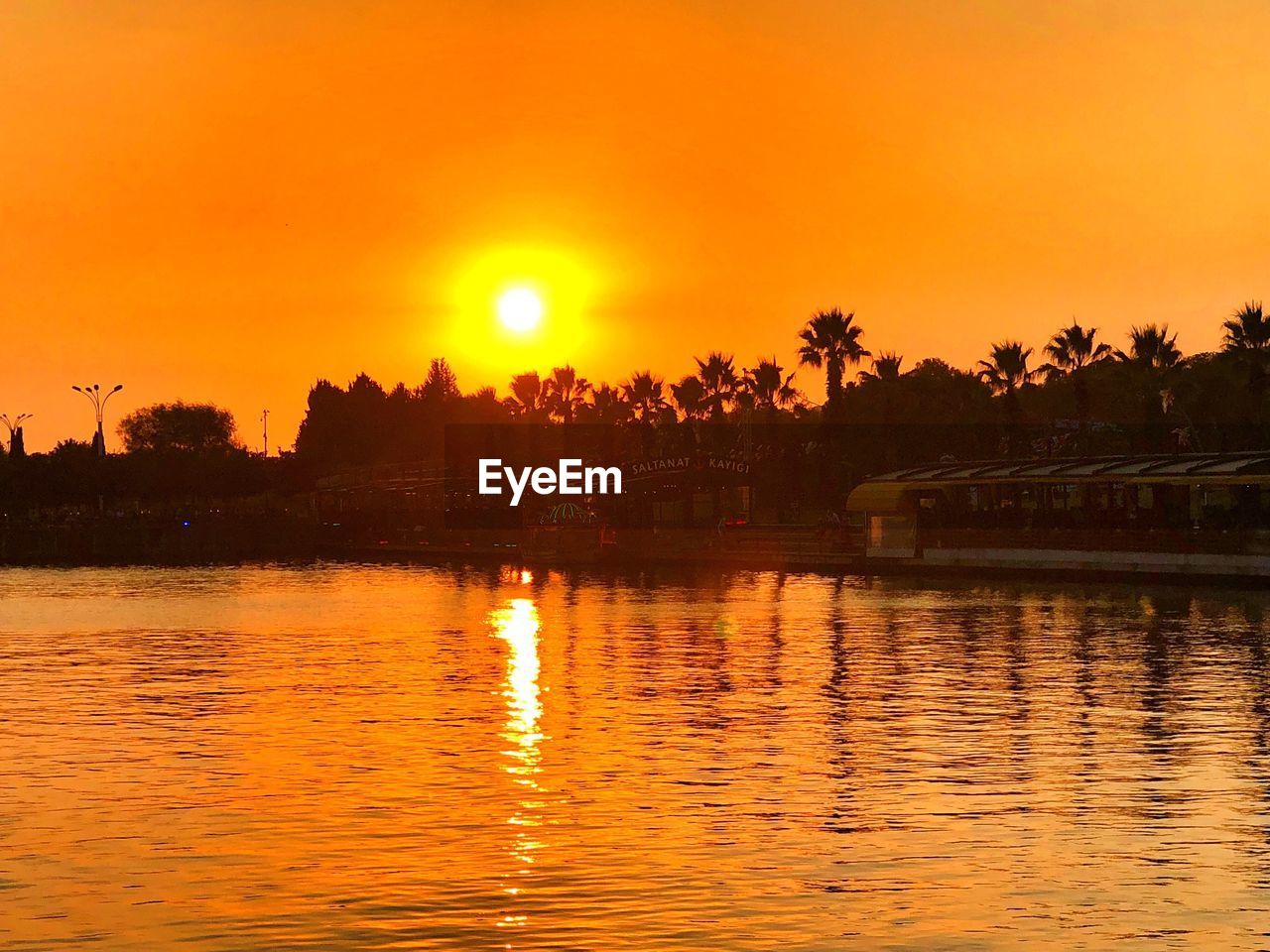 SCENIC VIEW OF LAKE AGAINST ORANGE SKY