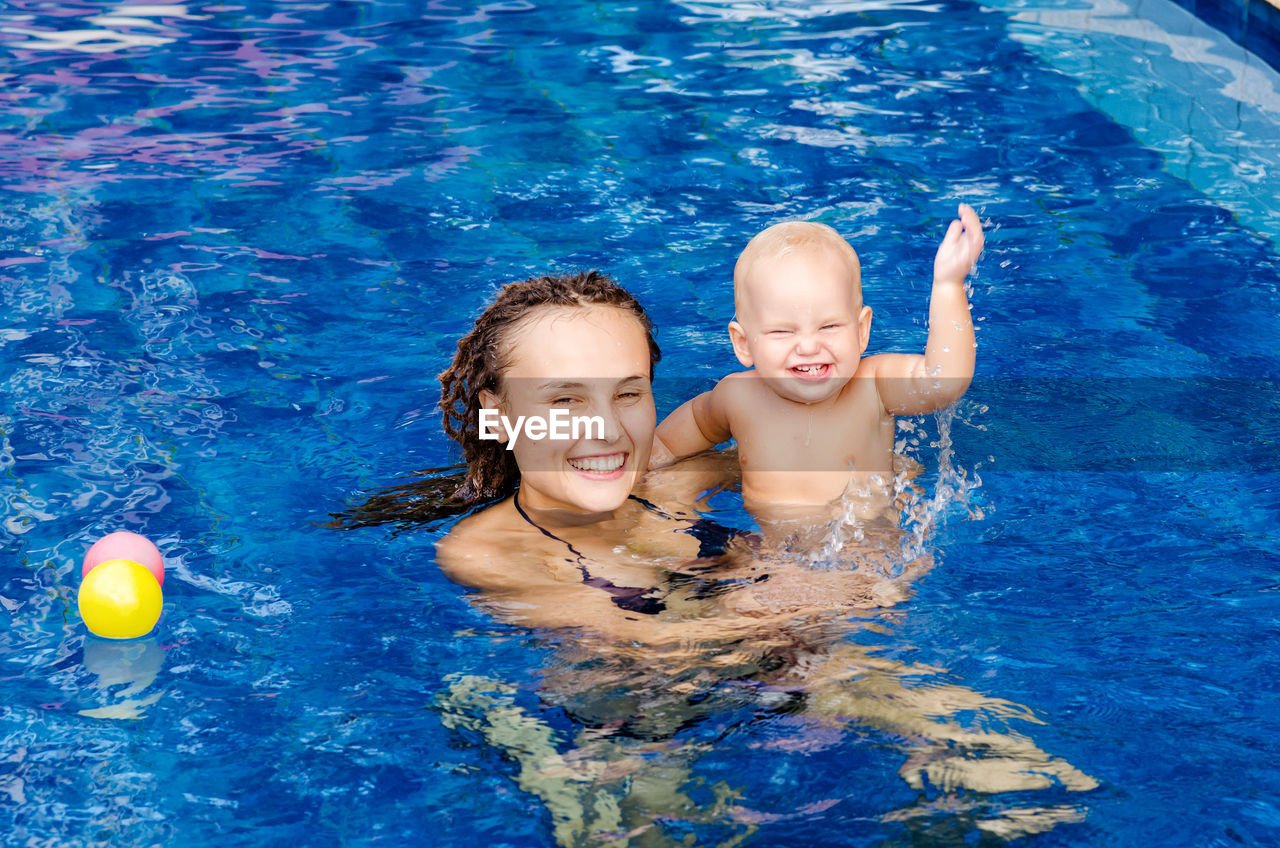 Woman with baby boy swimming in pool