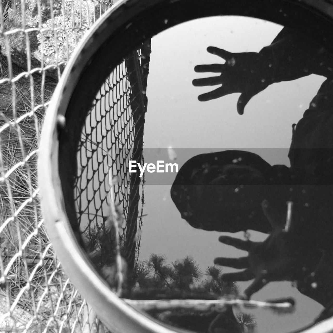 Reflection of man on water in container