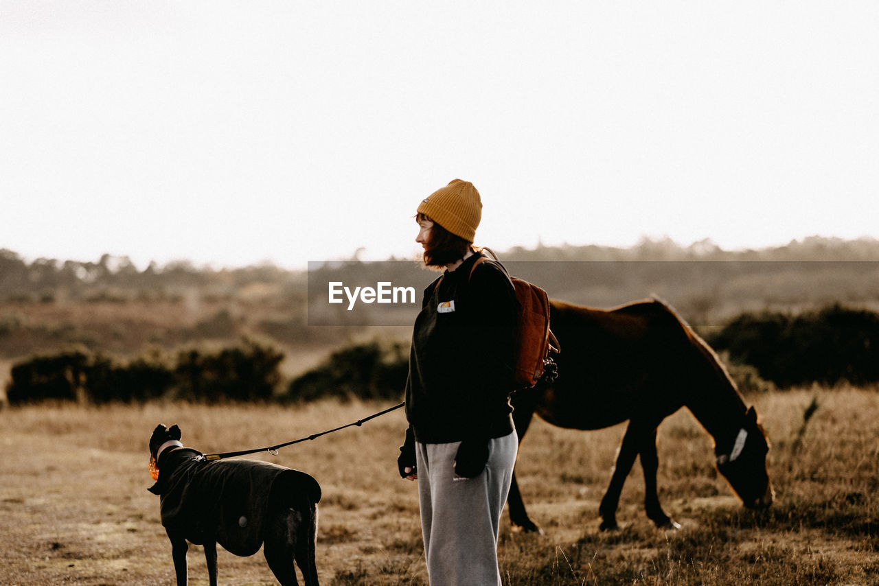 side view of man riding horse on field