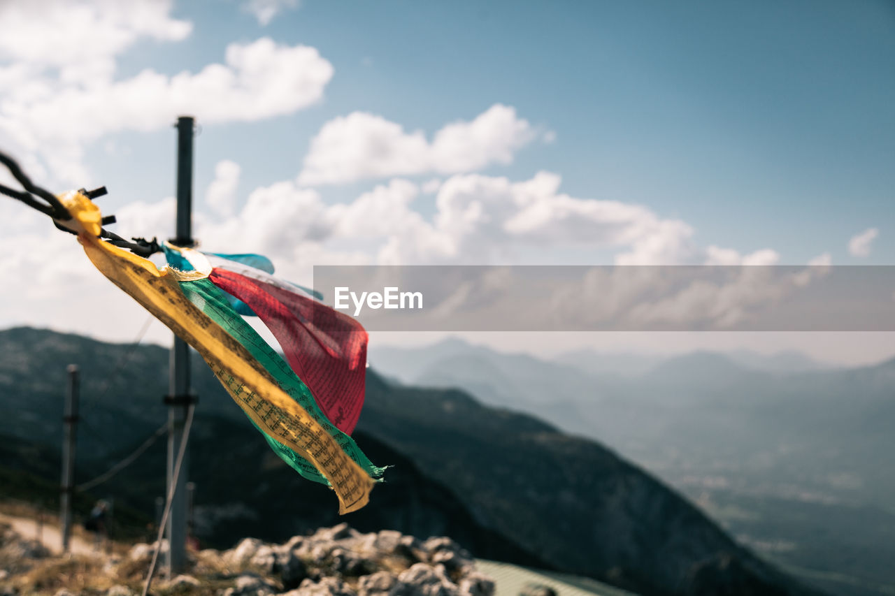 Multi colored flag on mountain against sky