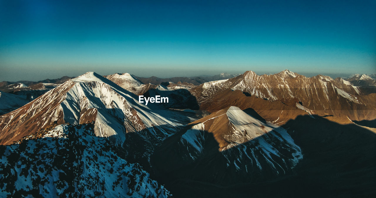 Scenic view of snowcapped mountains against blue sky