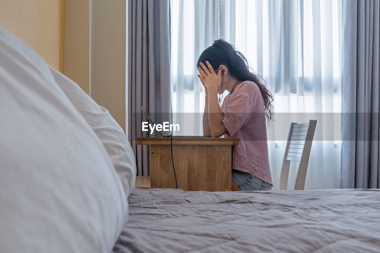 Feeling of stress and tired. woman holds her hands behind her head by working from home at laptop 