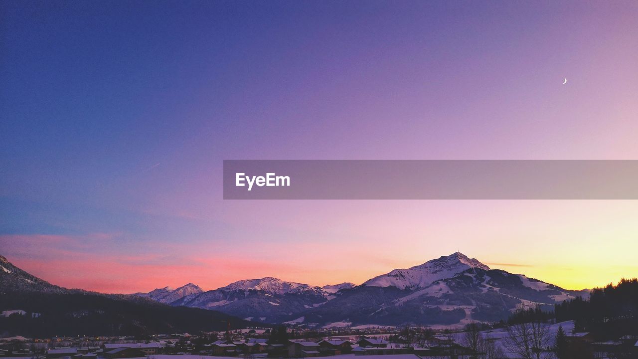 SNOWCAPPED MOUNTAINS AGAINST SKY DURING SUNSET