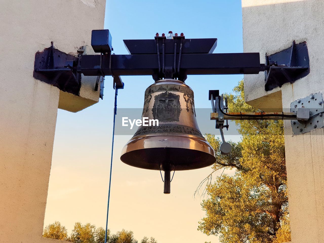 LOW ANGLE VIEW OF ELECTRIC LAMP HANGING AGAINST BUILDINGS