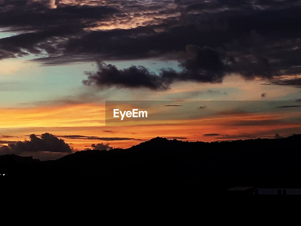 SCENIC VIEW OF SILHOUETTE MOUNTAINS AGAINST DRAMATIC SKY