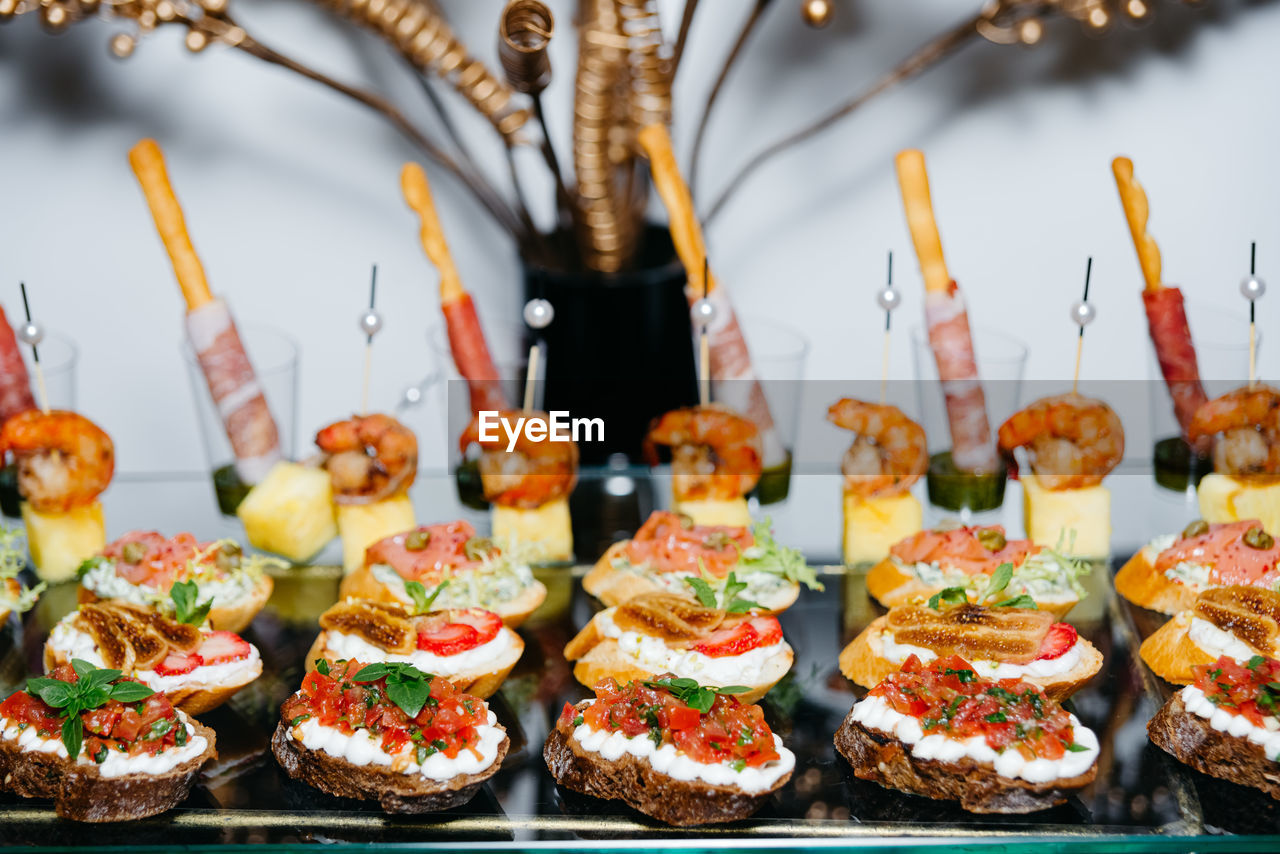 Rye bread bruschetta, cream cheese and salmon, shrimp and pineapple canapes on skewers