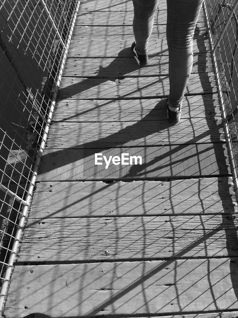 black, low section, black and white, shadow, human leg, white, monochrome photography, monochrome, one person, walking, sunlight, lifestyles, day, architecture, line, men, leisure activity, standing, built structure, adult, nature, outdoors, shoe, high angle view, footpath, pattern, limb, city, human limb, women, mesh, sports, metal
