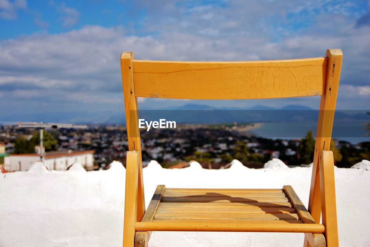 WOODEN CHAIR ON SNOW COVERED LAND