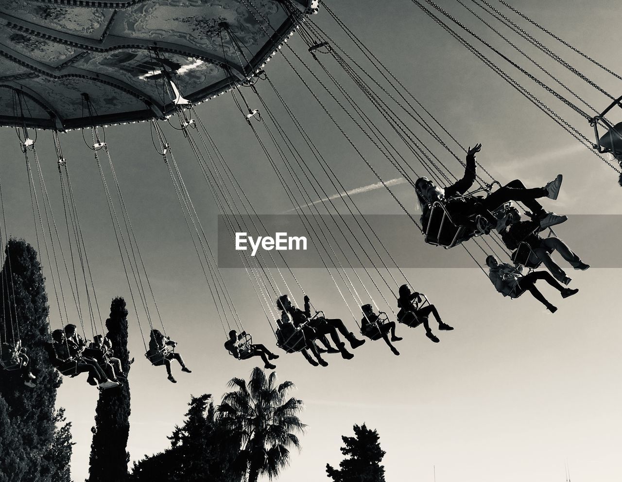 LOW ANGLE VIEW OF PEOPLE AT AMUSEMENT PARK RIDE