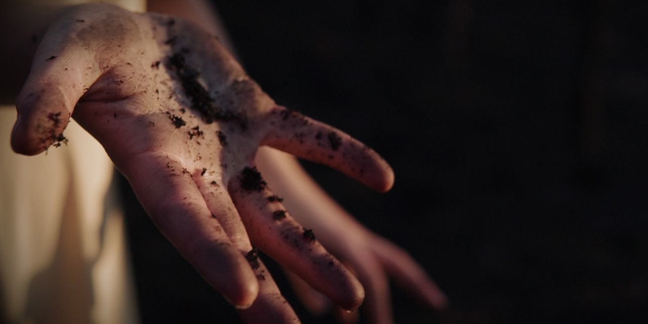 Close-up of dirty hand against black background