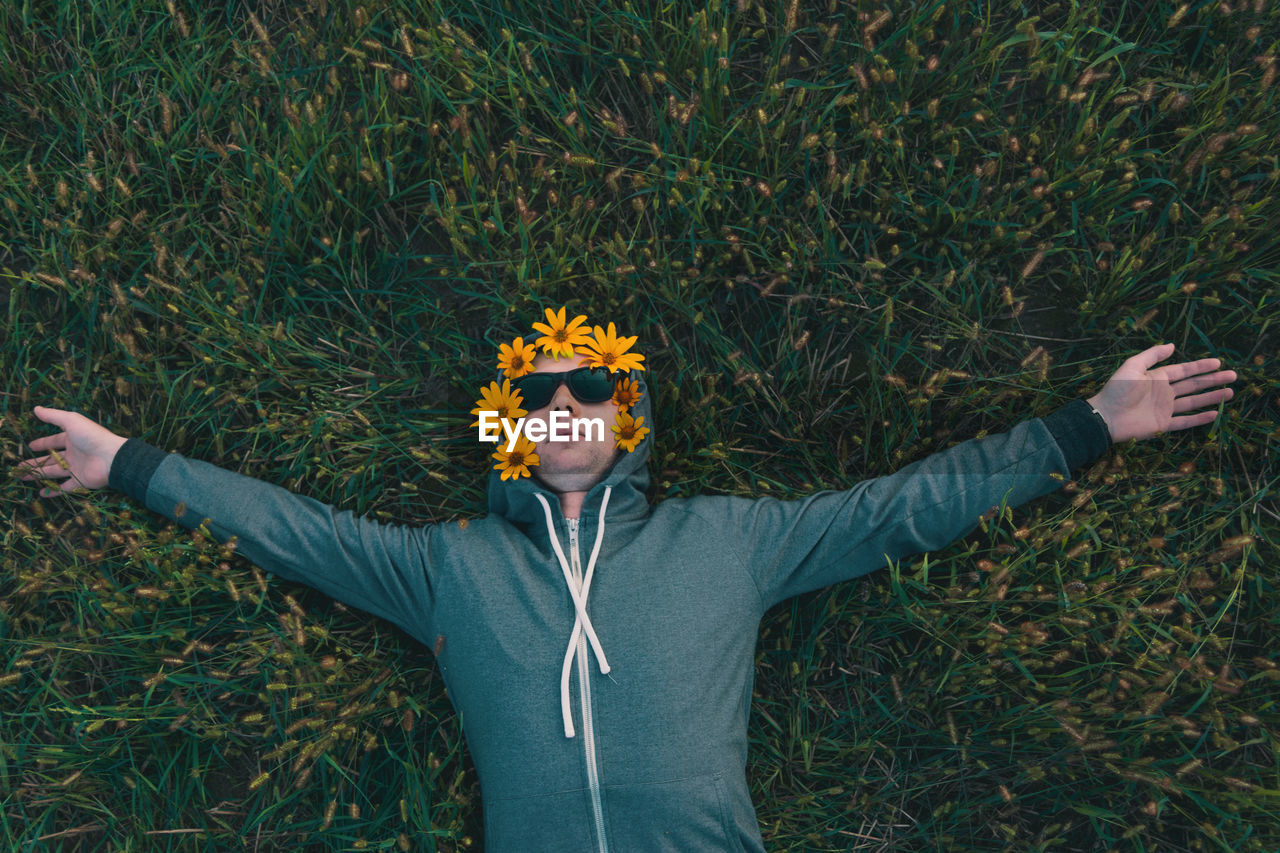 Portrait of young man wearing sunglasses while standing against plants