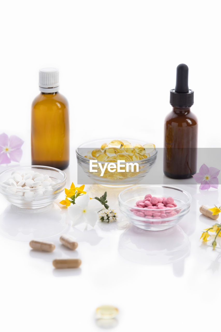 medicine, bottle, pill, healthcare and medicine, container, dose, aromatherapy, therapy, white background, food, studio shot, food and drink, flower, wellbeing, plant, flowering plant, nutritional supplement, body care, herbal medicine, alternative medicine, capsule, spa treatment, no people, indoors, alternative therapy, variation, aromatherapy oil, petal, freshness, still life, cut out, yellow, pharmaceutical drug, nature