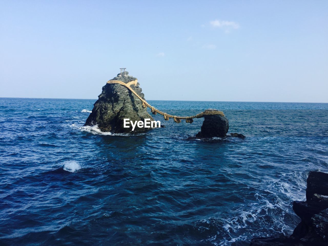 ROCKS IN SEA AGAINST CLEAR SKY