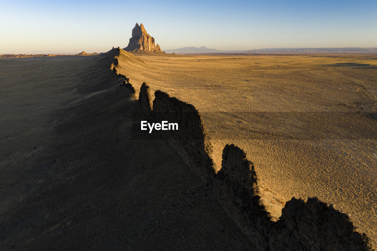 Aerial with leading line of lava towards shiprock in new mexico