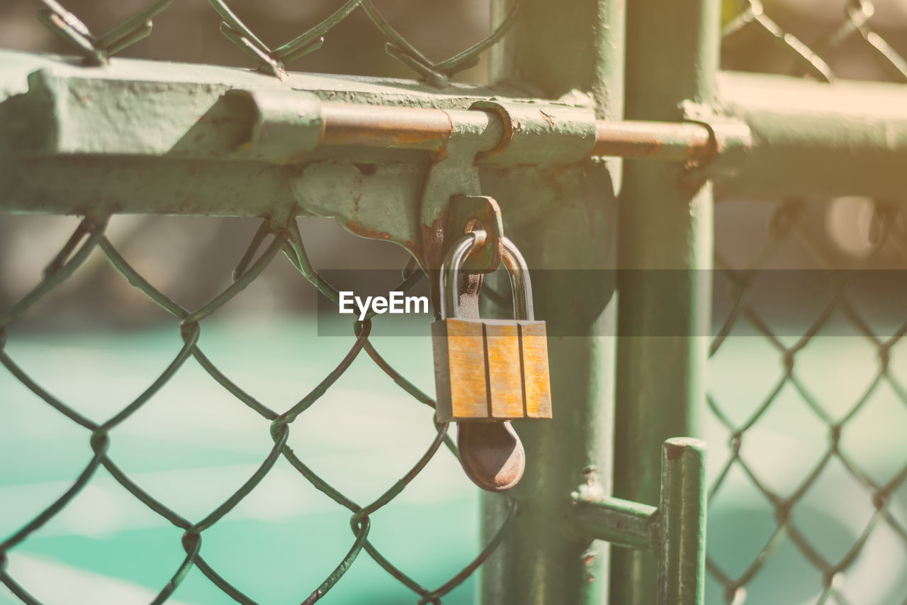 Close-up of padlock on chainlink fence