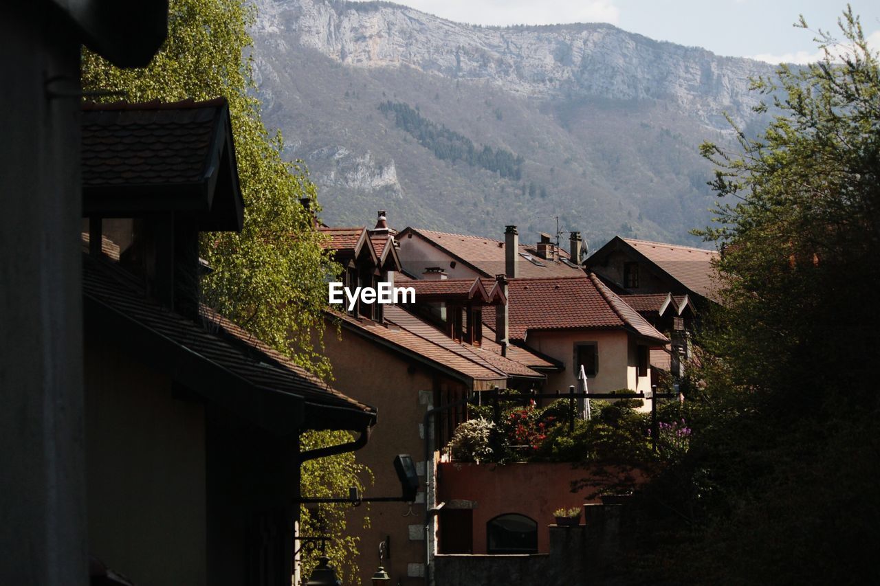 Houses in village by mountains against sky