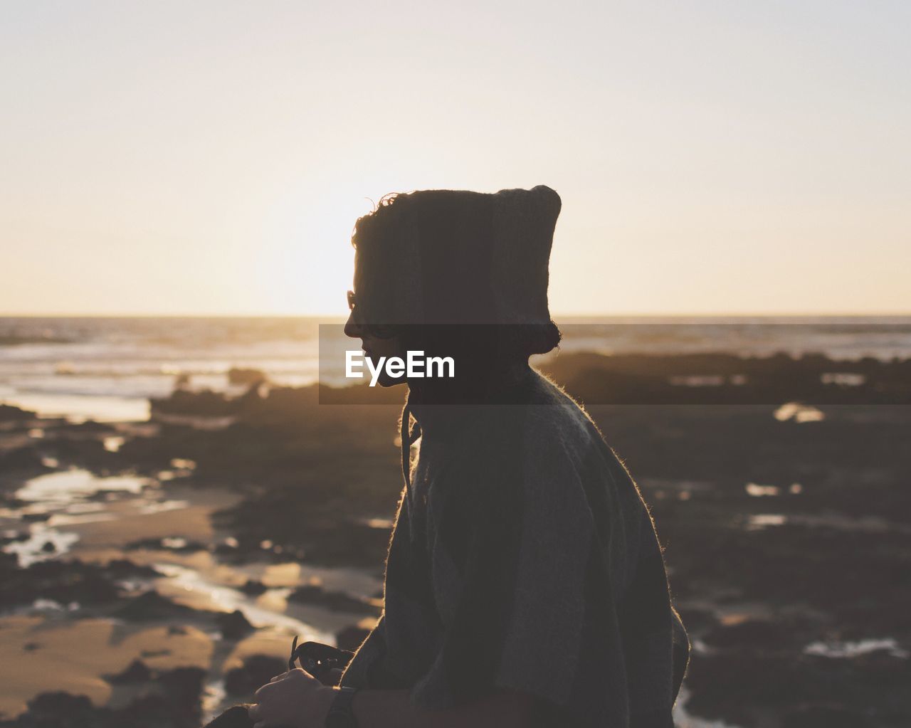 SIDE VIEW OF SILHOUETTE WOMAN STANDING ON BEACH AGAINST SKY