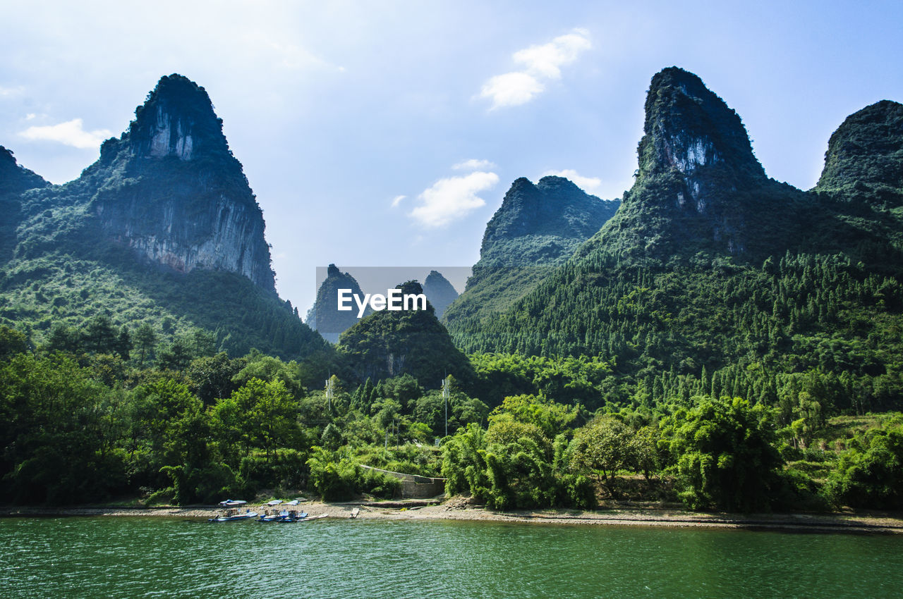 Scenic view of river and mountains against sky