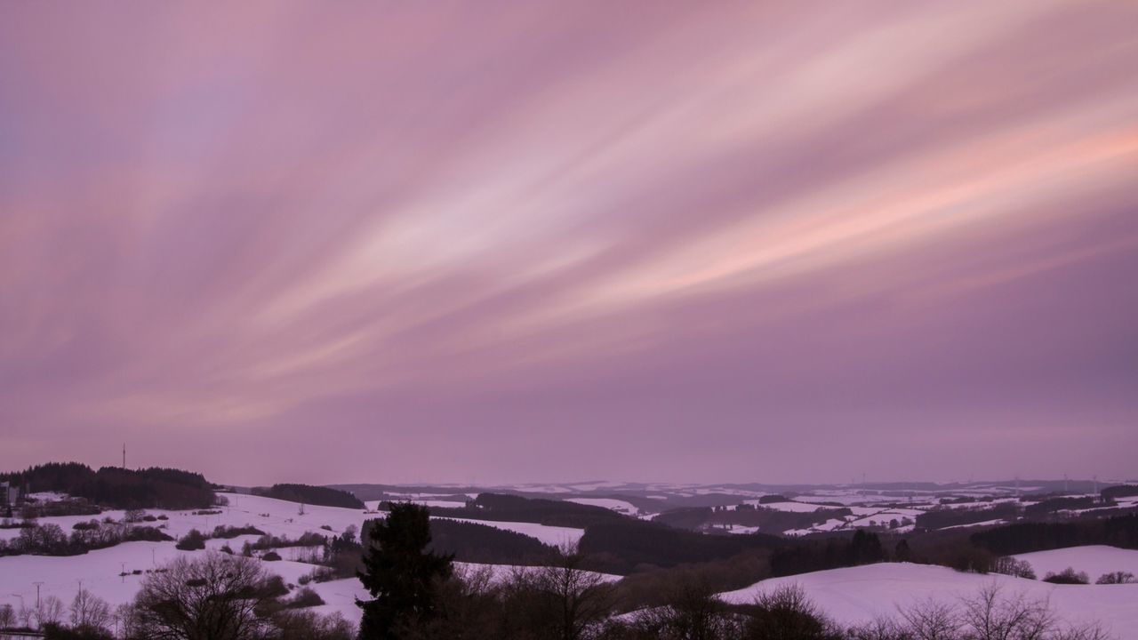 Scenic view of snow covered landscape against cloudy sky