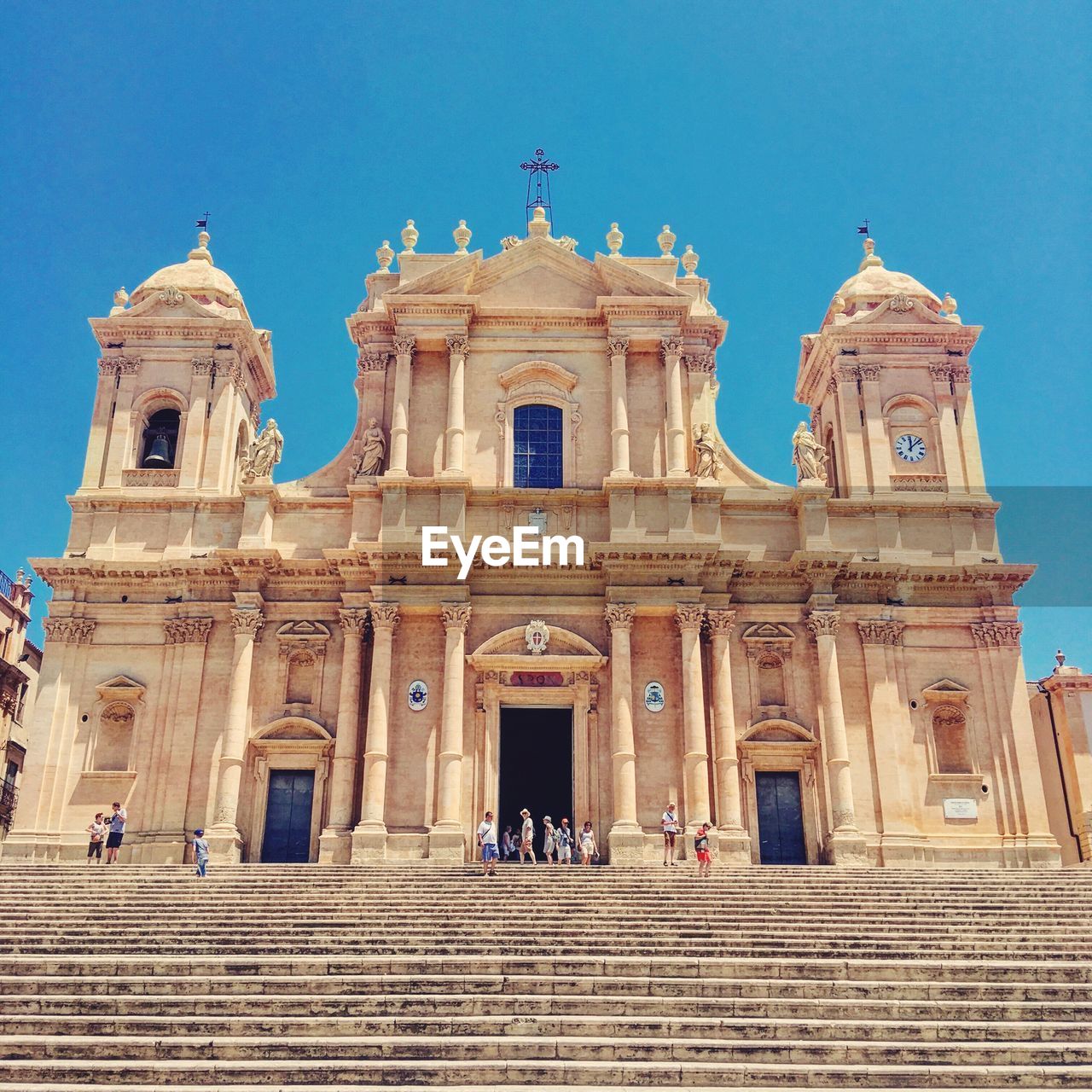 Low angle view of people at noto cathedral against clear sky