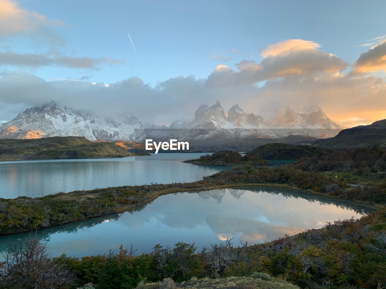 Scenic view of lake by mountains against sky