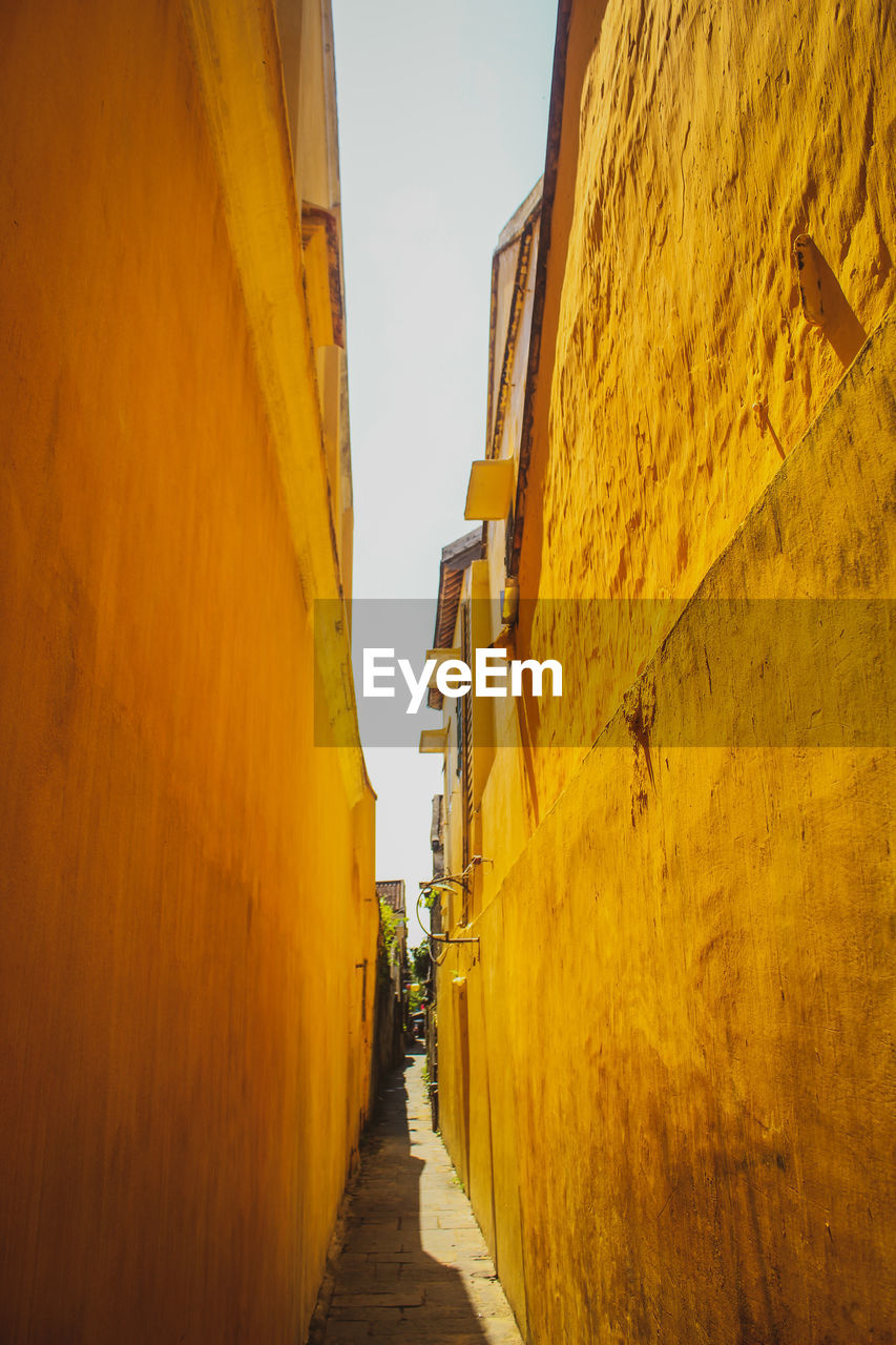 Narrow alley amidst buildings against sky