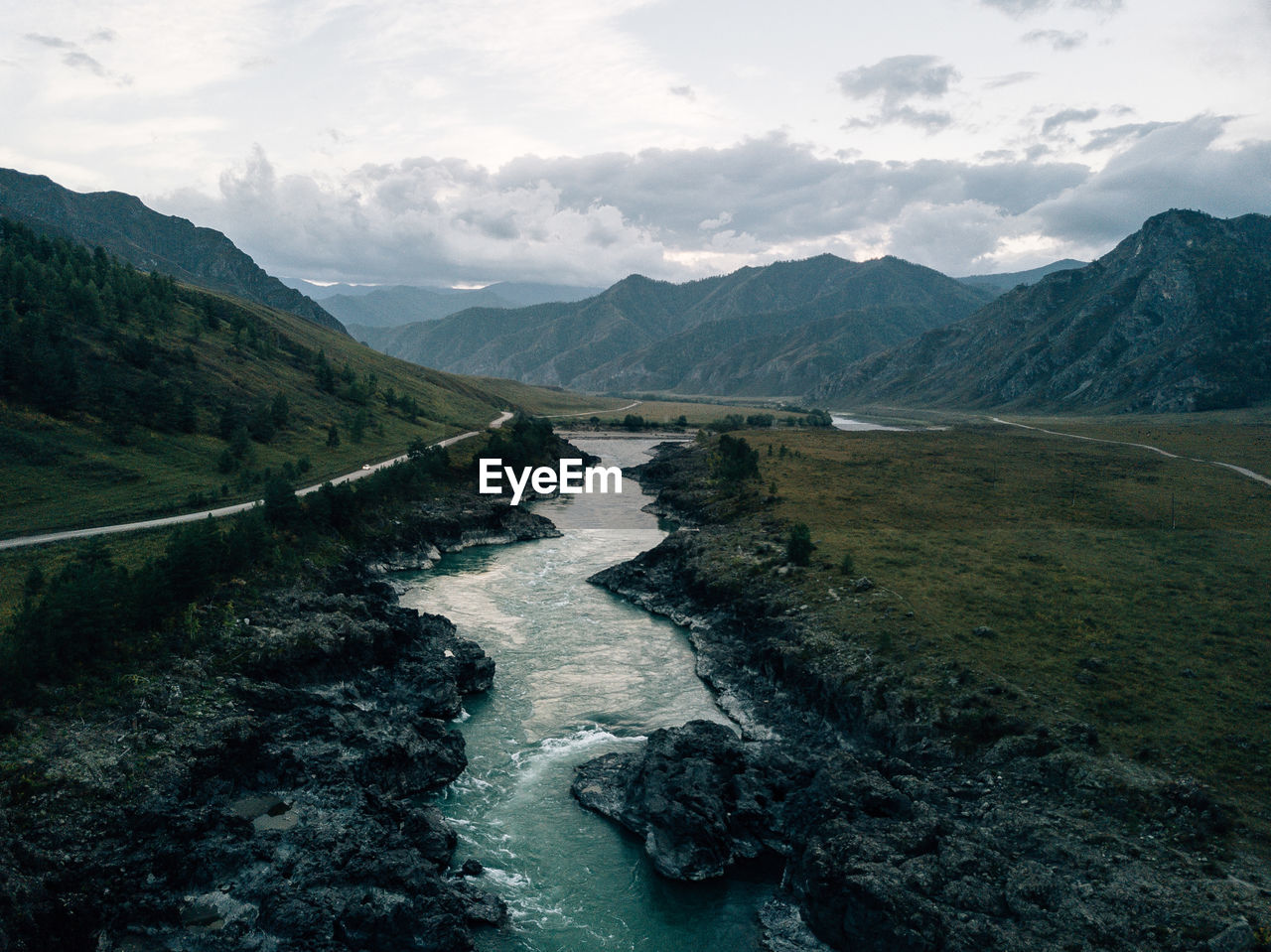 Scenic view of river amidst mountains against sky