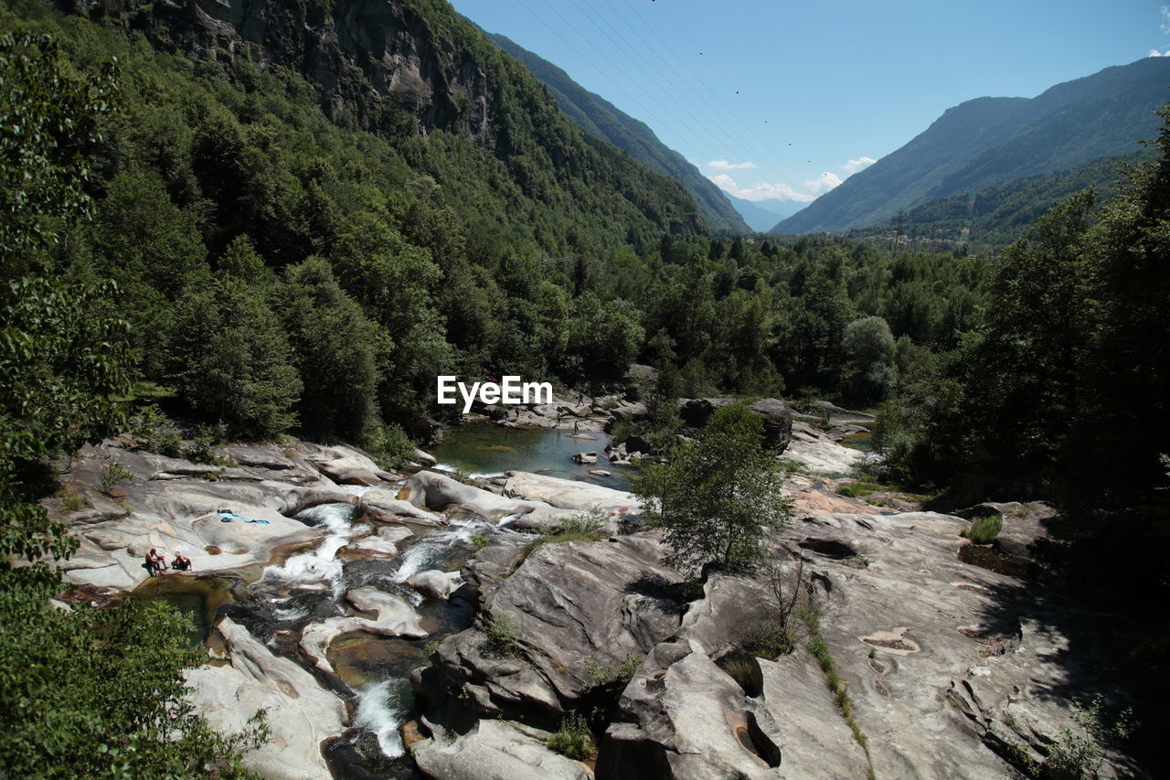 Scenic view of river by mountains against sky