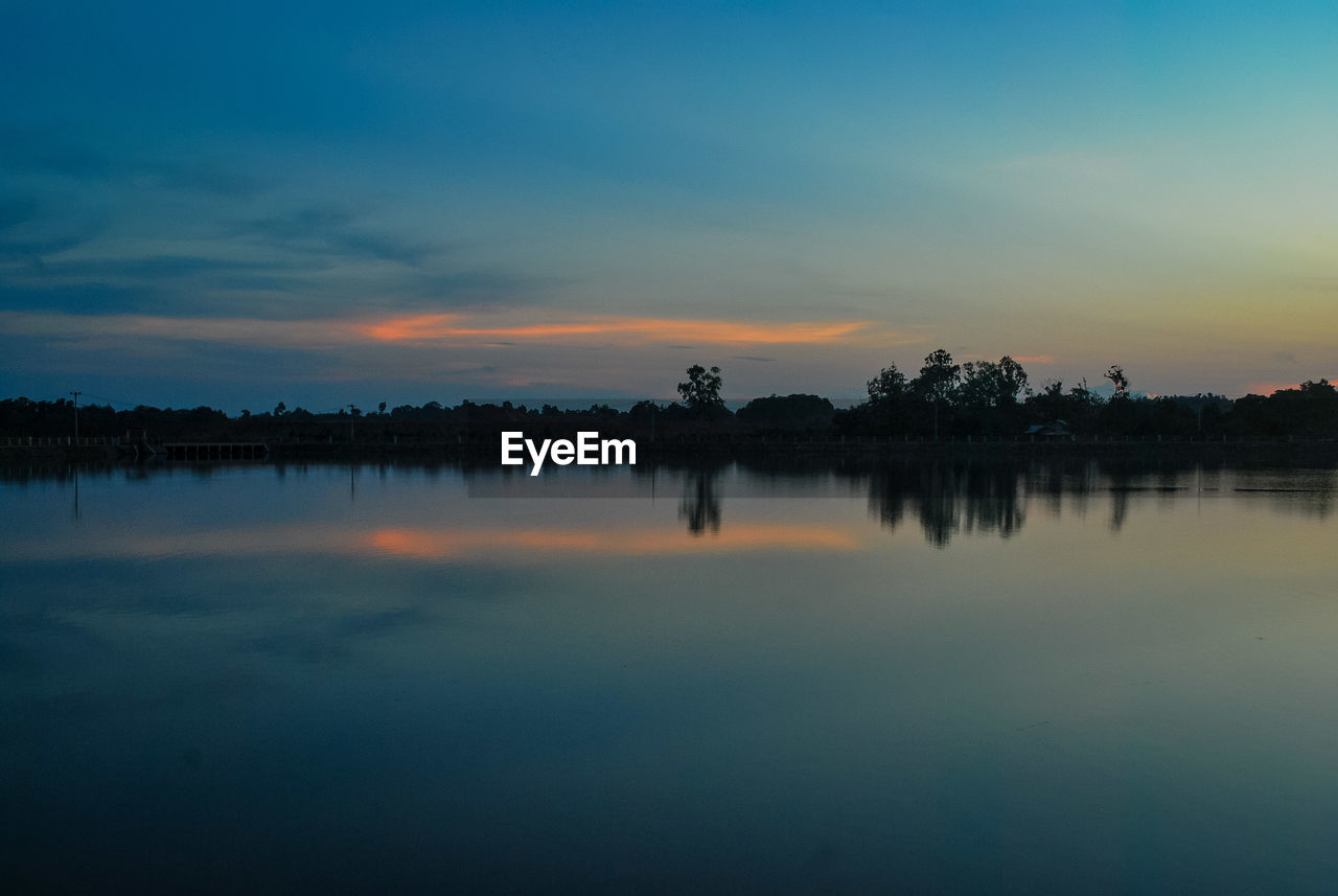 Scenic view of calm lake at dusk