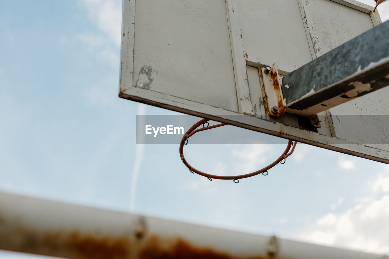 Old ruty basketball hoop against the sky