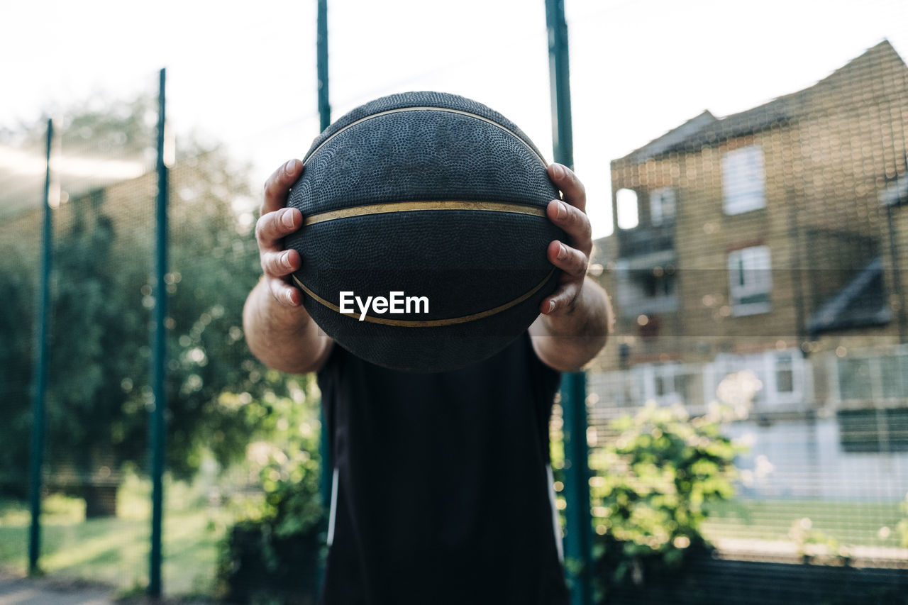 Athlete holding black basketball at court