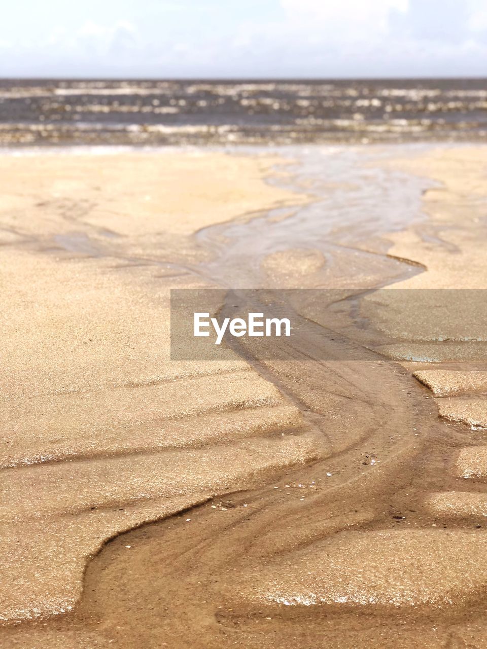 HIGH ANGLE VIEW OF WET SHORE AT BEACH