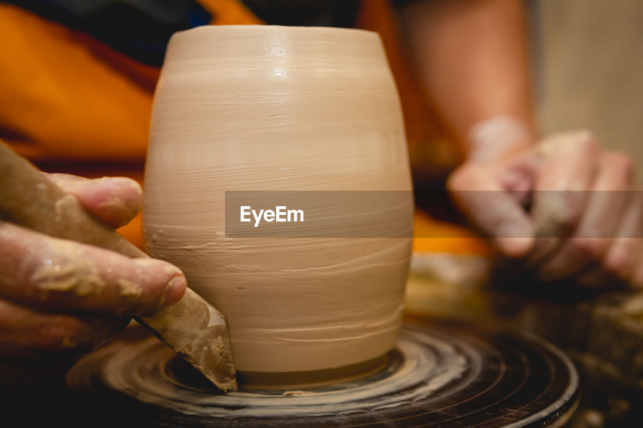 Cropped hands of potter making pot