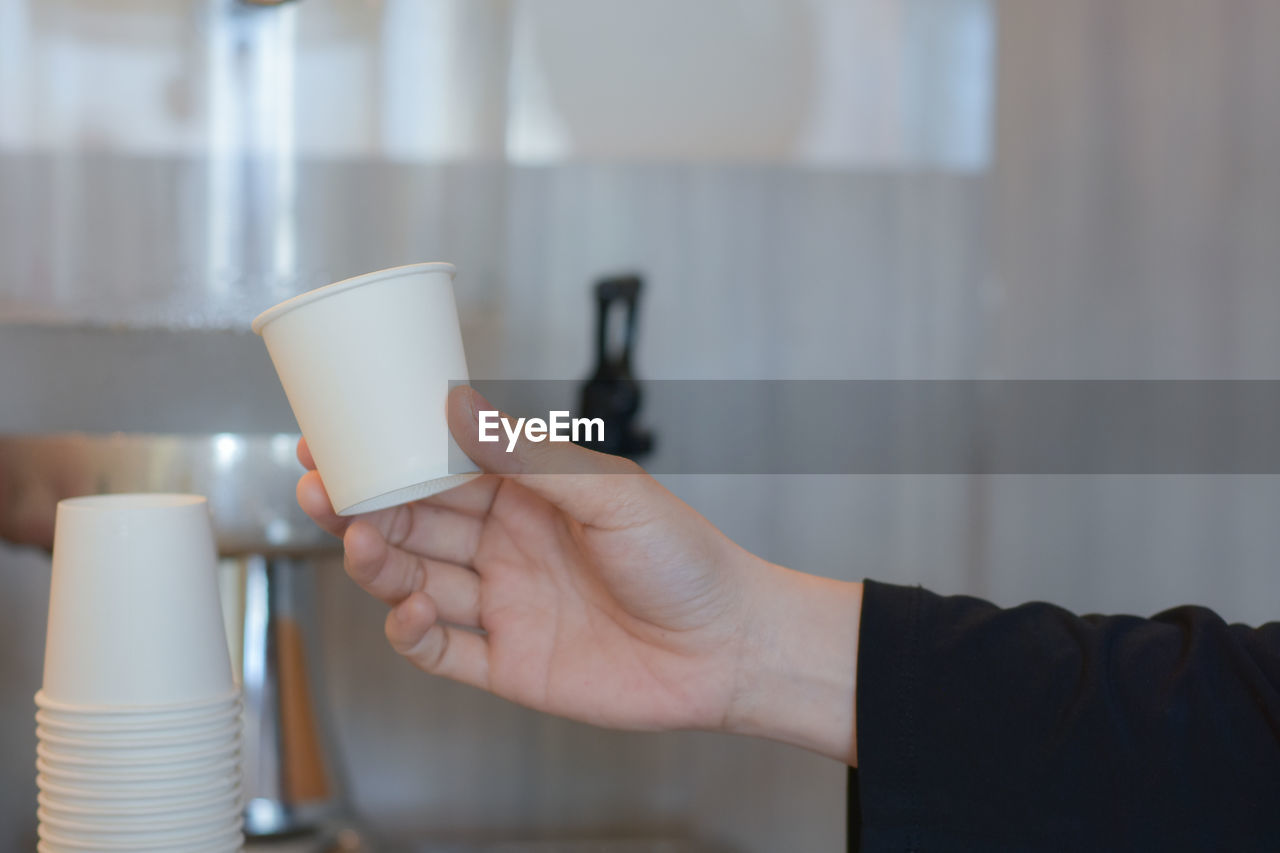 one person, hand, adult, holding, coffee, business, cup, indoors, coffee cup, drink, mug, food and drink, focus on foreground, refreshment, close-up, women, lifestyles, young adult, occupation, lighting, working, copy space, hot drink, cafe, domestic room