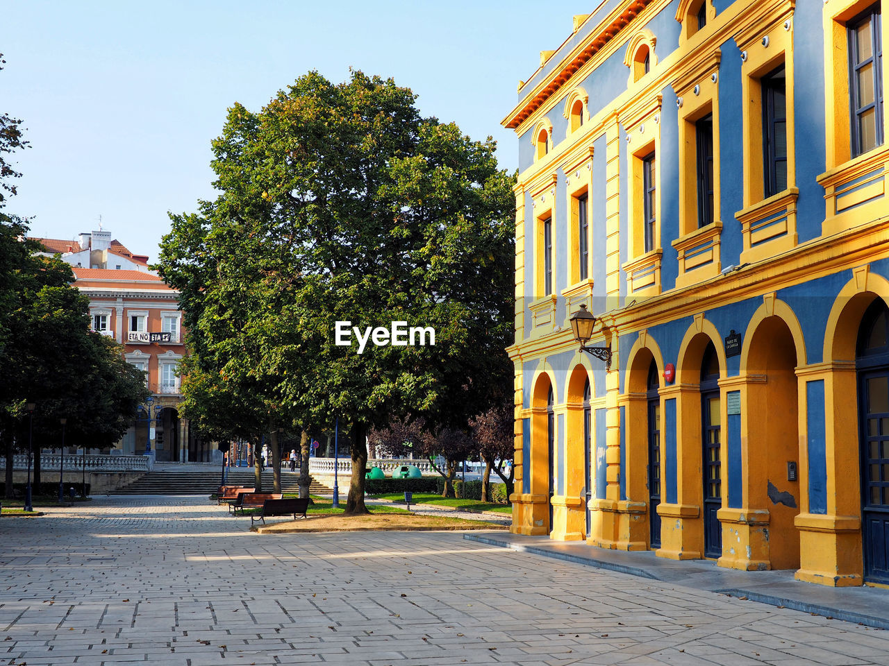 STREET BY BUILDINGS AGAINST SKY